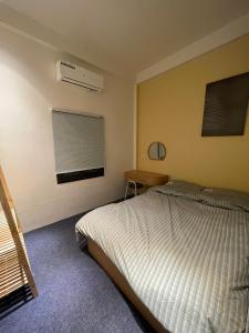 um quarto com uma cama, uma escrivaninha e uma janela em Le Balcon Hanoi em Hanói