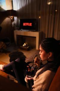 a woman sitting on a couch in front of a fireplace at Pousada e Chalé Lote 22 in Ilha do Mel