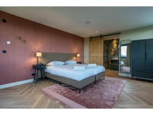 a bedroom with a large bed and a pink wall at Modern villa in De Cocksdorp near the beach in De Cocksdorp