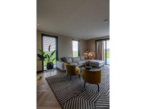 a living room with a couch and a table at Modern villa in De Cocksdorp near the beach in De Cocksdorp +29 photos