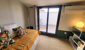 een kamer met een bank en een raam met een balkon bij Townhouse with rooftop in Pernes-les-Fontaines