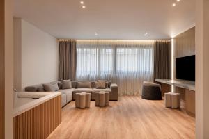 a living room with a couch and a television at Nur City Suites in Athens