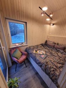 a small bedroom with a bed and a window at Holiday cabin 'OAK' in Salacgrīva