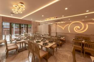 a restaurant with tables and chairs in a room at Gopuram Grand in Madurai +27 photos