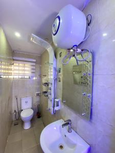 Un baño con inodoro y una cámara en la pared. en Fola Homes, en Suru Lere