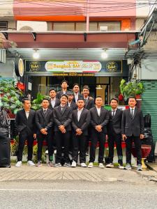 COZY Bangkok BM B&B في Amphoe Phra Khanong: مجموعة من الرجال يرتدون بدلات يقفون أمام مبنى +58 صورة