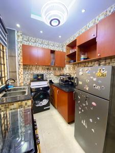 Una cocina con refrigerador y gabinetes de acero inoxidable. en Fola Homes, en Suru Lere