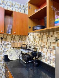 Una cocina con gabinetes de madera y encimera. en Fola Homes, en Suru Lere 23 fotos más