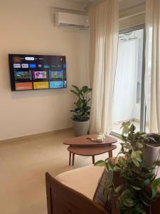 a living room with a table and a tv on the wall at Capibara 6 - Vistas de Junin in Corrientes
