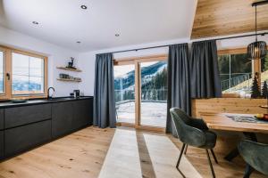 a kitchen with a table and a view of a mountain at Moidi's Chalet Spieljoch in Fügenberg