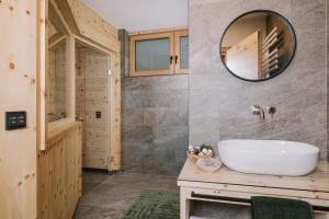 a bathroom with a white sink and a mirror at Moidi's Chalet Spieljoch in Fügenberg +37 photos