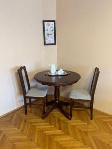 een houten tafel met twee stoelen en een tafel met een kopje bij Il Teatro in Oradea