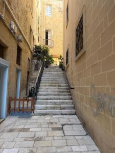 a stone alley with a staircase leading up to a building at 3 St Anne's Street in Valletta