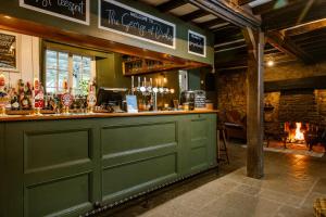 a bar with a green door and a fireplace at The George Inn in Lower Brailes