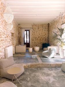 a room with couches and chairs in a stone wall at Alphea1570 in Lloseta