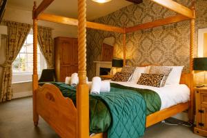 a bedroom with a wooden four poster bed at The George Inn in Lower Brailes +39 photos