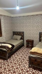 1 dormitorio con 2 camas y pared estampada en Auberge panorama, en Kasba des Aït Athmane
