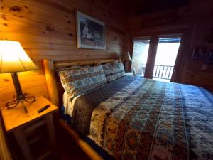 um quarto com uma cama num chalé de madeira em The Reservation- On the River em Cove Creek Cascades