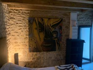 een schilderij van een gezicht aan de muur van een slaapkamer bij Domaine de Jarville in Aufferville