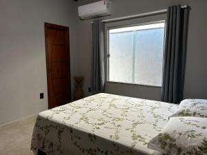 a bedroom with a bed and a window at Casa da Sil in Arraial d'Ajuda