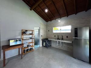 a kitchen with a stainless steel refrigerator and a counter at Casa da Sil in Arraial d'Ajuda