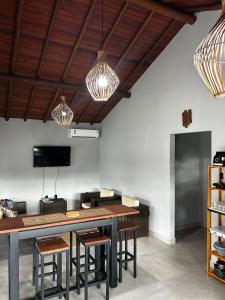 a kitchen with a table and some chairs and lights at Casa da Sil in Arraial d'Ajuda