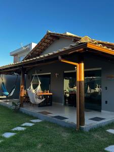 a house with a porch with a hammock on it at Casa da Sil in Arraial d'Ajuda