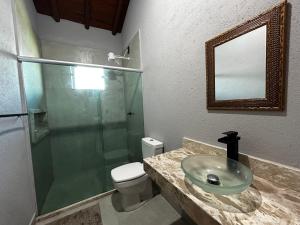 a bathroom with a sink and a toilet and a glass shower at Casa da Sil in Arraial d'Ajuda +46 photos