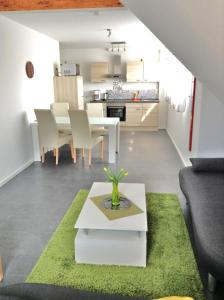 - un salon avec une table blanche et un tapis vert dans l'établissement Murthum Gästeappartments, à Leinfelden-Echterdingen