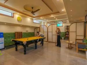 a man and a woman standing in a room with a pool table at The Hosteller Agra, Tajganj in Agra