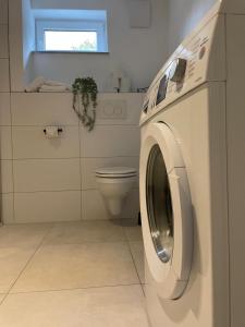 a washing machine in a bathroom with a toilet at Premium-Apartment, 4 Betten, Nahe Ulm für Familien und Gruppen,Hund in Blaustein