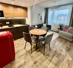 a kitchen and living room with a table and chairs at SPV Rentals Pileckiego 59 lokal 258 free Parking Ursynów in Warsaw
