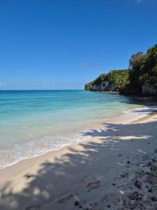 a beach with a shadow of a person on the sand at Vi la dous Kreyol in Sainte-Rose