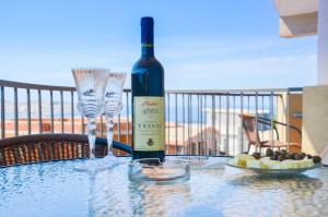 a bottle of wine sitting on a table with wine glasses at Apartment Sea & Mountain in Bar