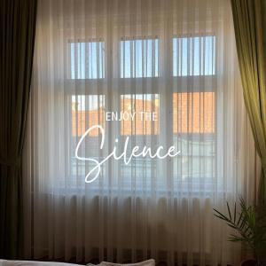 een raam met een wit gordijn waarop de woorden 'ken het verschil' staan bij Il Teatro in Oradea +2 foto's