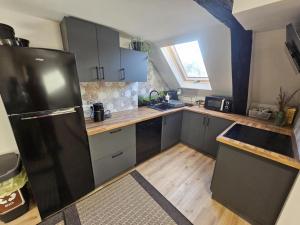 cocina con nevera negra y suelo de madera en Osmelakowa Dolina, en Spalona