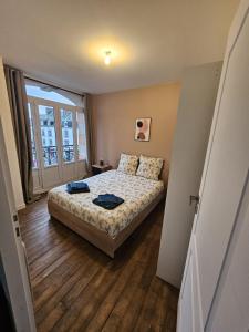 a bedroom with a bed and a large window at L'Authentique - Appartement 6 in Loudéac