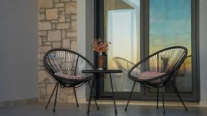 Dos sillas y una mesa frente a una ventana. en One Lemnos Apartments, en Limnos