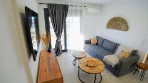 Una sala de estar con un sofá azul y una mesa. en One Lemnos Apartments, en Limnos