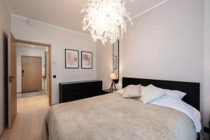 a bedroom with a large bed and a chandelier at Siili Riverview Stay in Tartu
