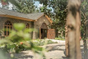 a small brick building with a door in a garden at Mtoni River Lodge in Arusha +28 photos