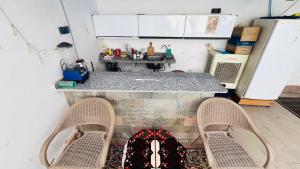 a kitchen with a counter with two chairs and a backpack at Tara Apartments in Luxor