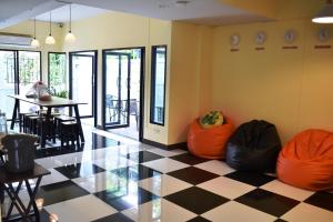 a room with a checkered floor with chairs and a table at Hide Bangkok Hostel in Bangkok