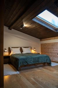 a bedroom with a large bed with a skylight at Вила Вяра, Надежда, Любов in Neofit Rilski