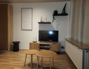 a living room with a television and a table and stool at Studio Avondzon in Blankenberge