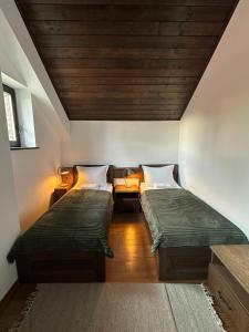 a room with two beds and a wooden ceiling at Вила Вяра, Надежда, Любов in Neofit Rilski