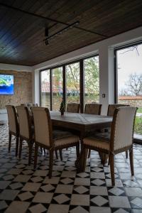ein Esszimmer mit einem großen Holztisch und Stühlen in der Unterkunft Вила Вяра, Надежда, Любов in Neofit Rilski