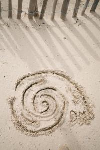Le Domaine de la mer - Beach hotel Nature&Authenticité Hyères في هييريس: حلزون مرسوم على الرمال على الشاطئ