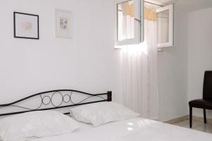 a bedroom with a bed and a chair and a window at Large and charming apartment near beach with big & sunny terrace in Sumartin