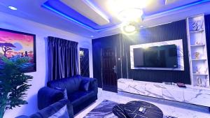 una sala de estar con un sofá y un televisor en Kunbiz Apartments, en Murtala Muhammed International Airport